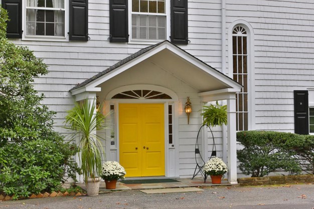 Exterior of yellow painted Tuscan villa with white shutters on half-glazed  double doors Stock Photo - Alamy